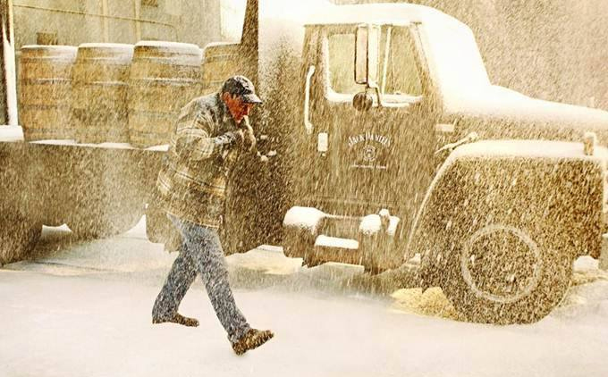 Man in snow with JD truck